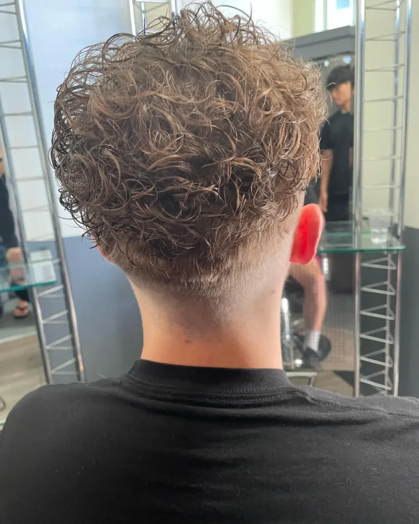 Hippie perm from the back — small, dense curls creating full retro texture