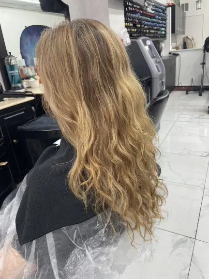 Golden blonde hair accented with brighter, warm-toned blonde highlights