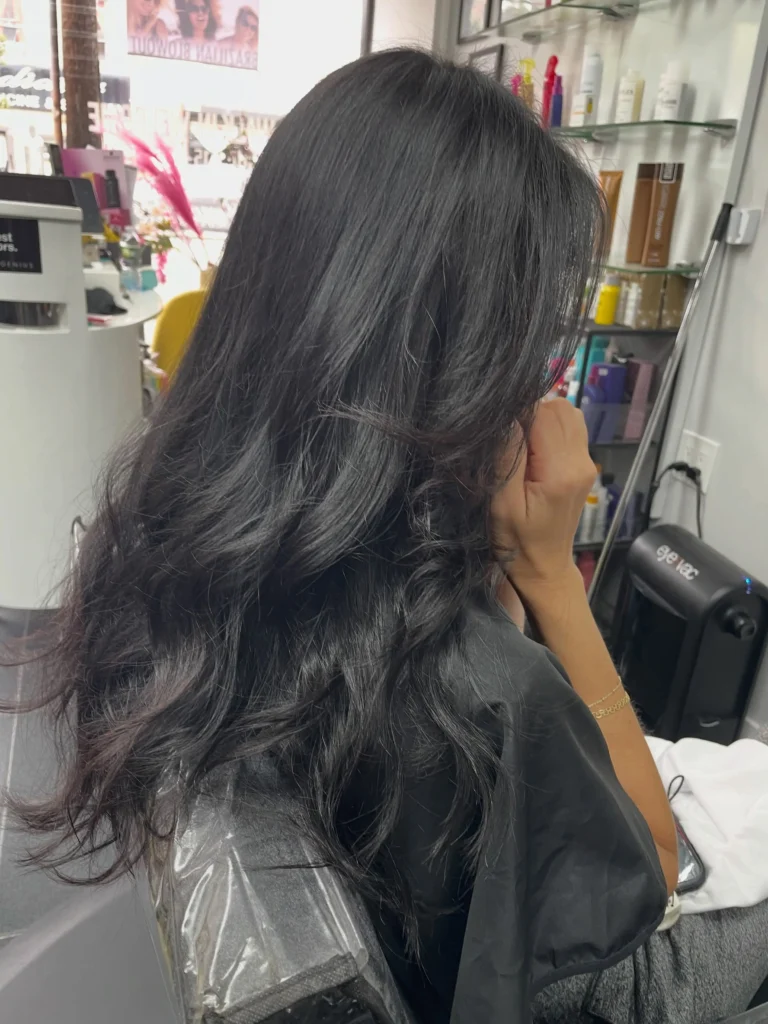 Korean blowout hairstyle featuring silky volume at the roots and loose bouncy curls