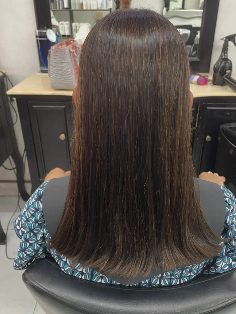 One length straight haircut with a clean blunt cut and smooth shiny finish and dark brown coloring