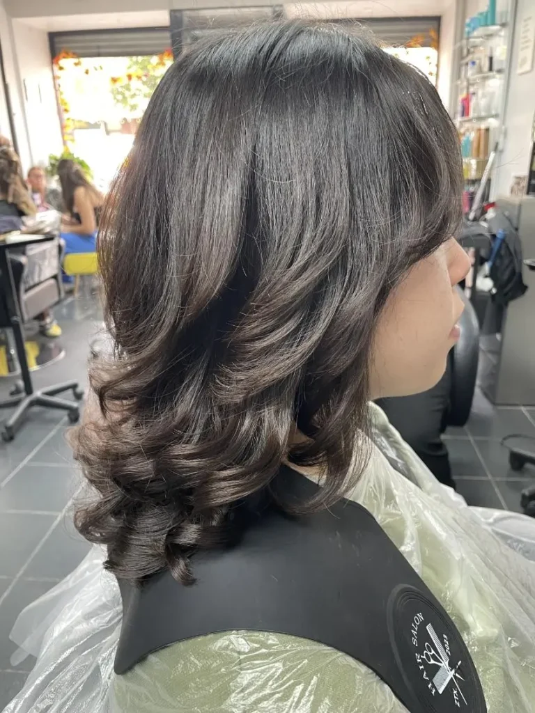 Layered shoulder-length haircut seen from the side, with textured, feathered ends