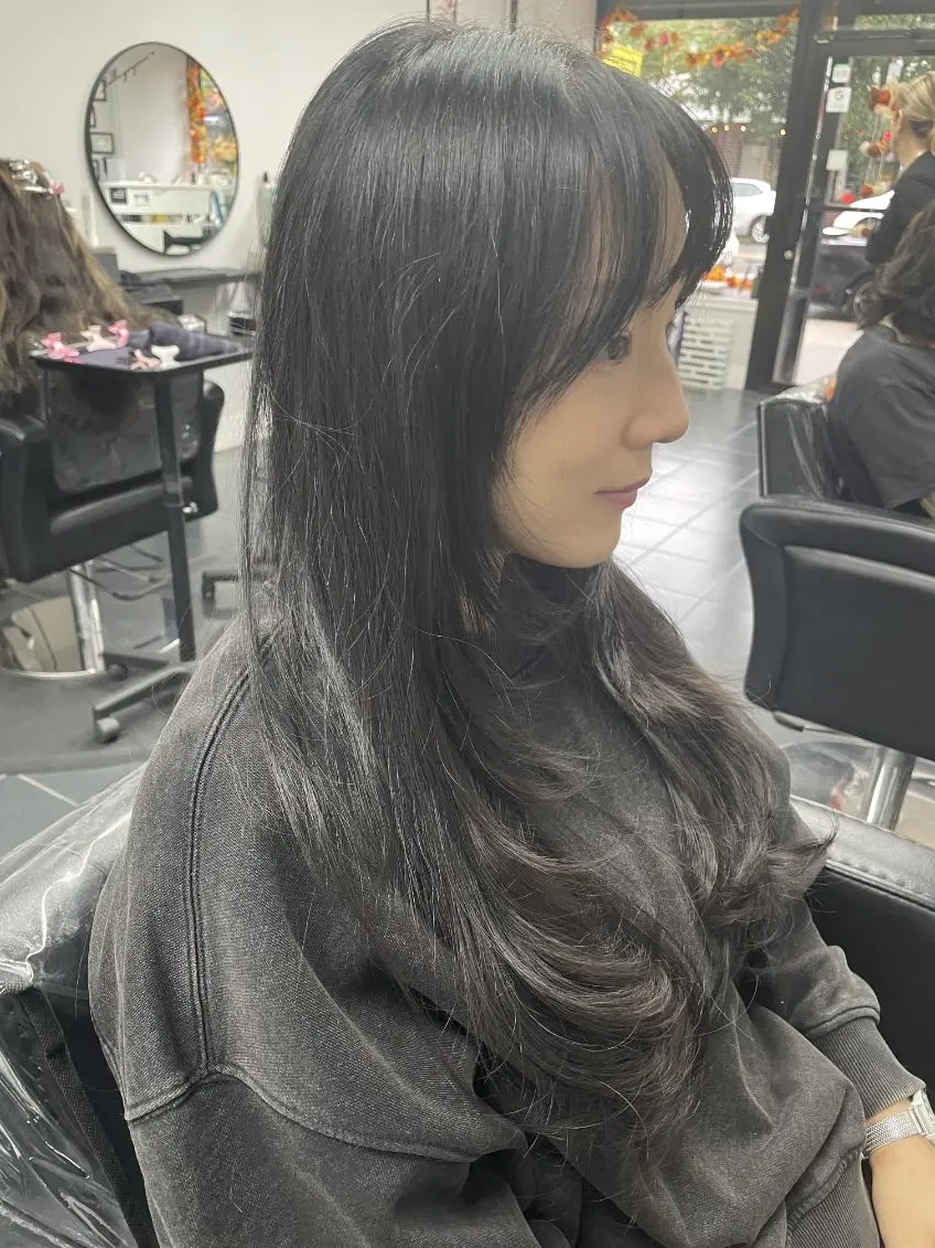 Long layered haircut with soft face-framing layers, side view